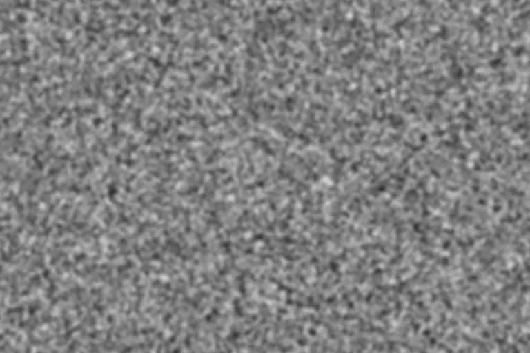 Neutral-gray 16mm-scale film grain texture with visible medium clusters