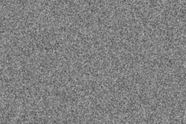 Neutral-gray 35mm-scale film grain texture with fine clustered grain